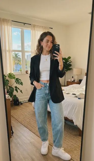 Woman wearing feminine streetwear outfit with baggy jeans and blazer