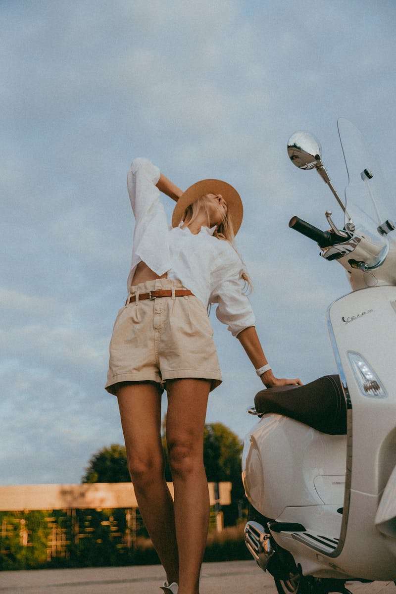 Fashionable young woman in sunglasses and summer outfit posing on a city street