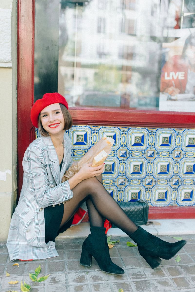 Smiling woman in beret and plaid blazer with a French bag, classic Parisian street style